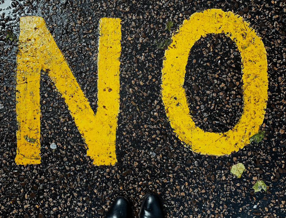 Een afbeelding met gele letters: NO, ter illustratie voor blog over omgaan met weerstand